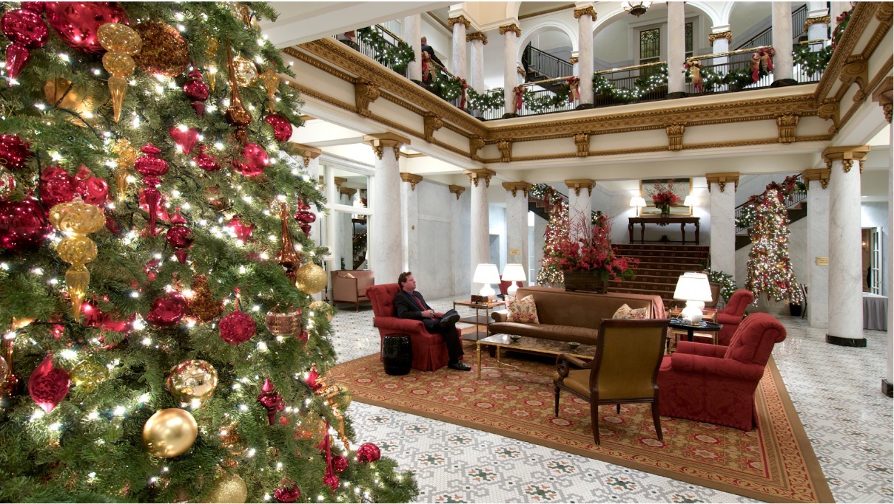 Vestíbulo de hotel decorado para Navidad con árbol.