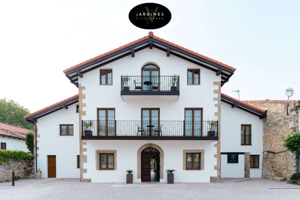 Fachada blanca de casa rural con balcones
